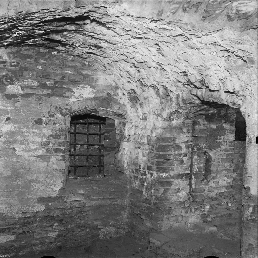 BDSM Dungeon-utrustning från Chambers of Love - stenvalv och rustik dungeonmiljö i svartvitt