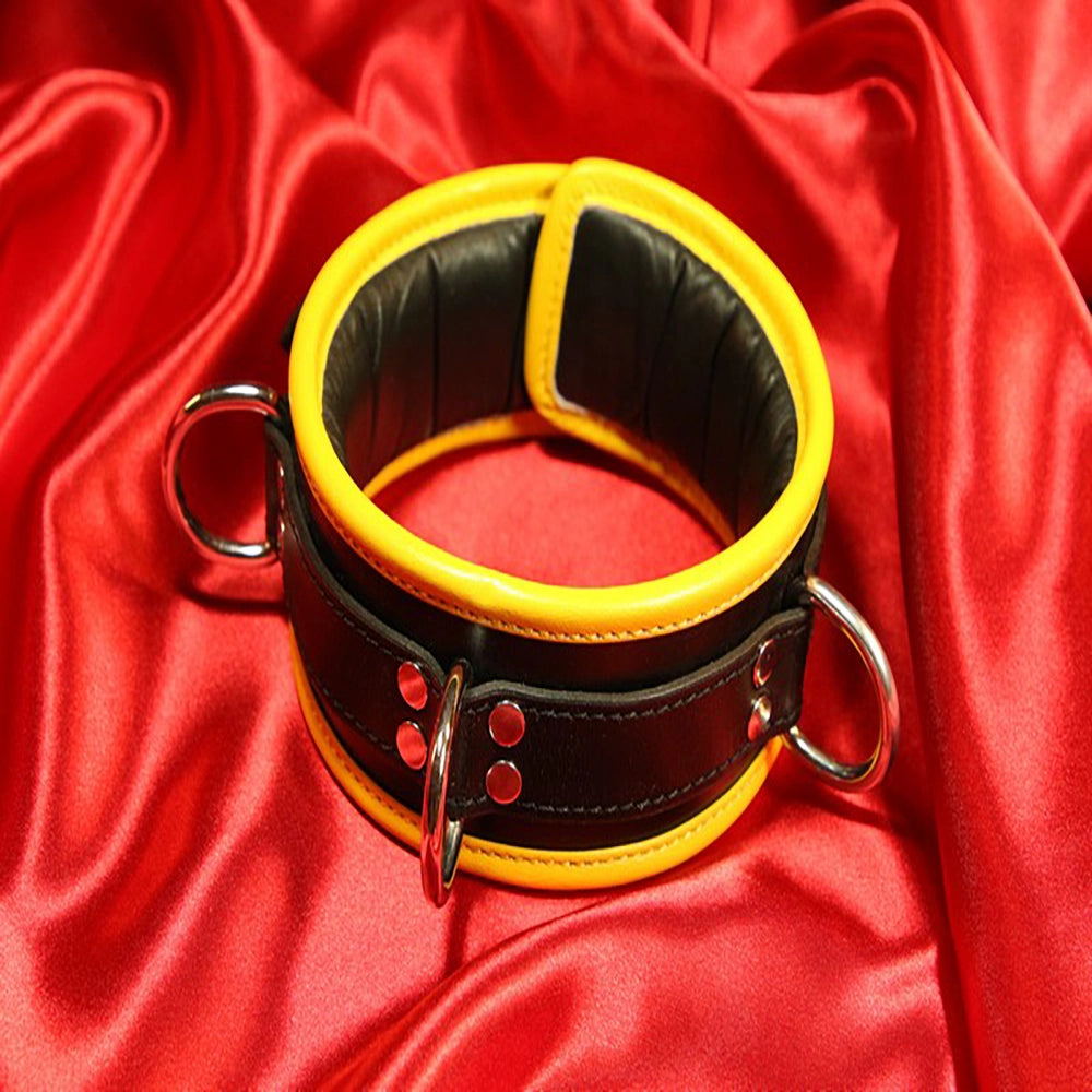 BDSM-halsband 3 D-ring – gult vadderat läderhalsband – framsida med 3 D-ringar hankykod vattensport på röd satin från Chambers of Love