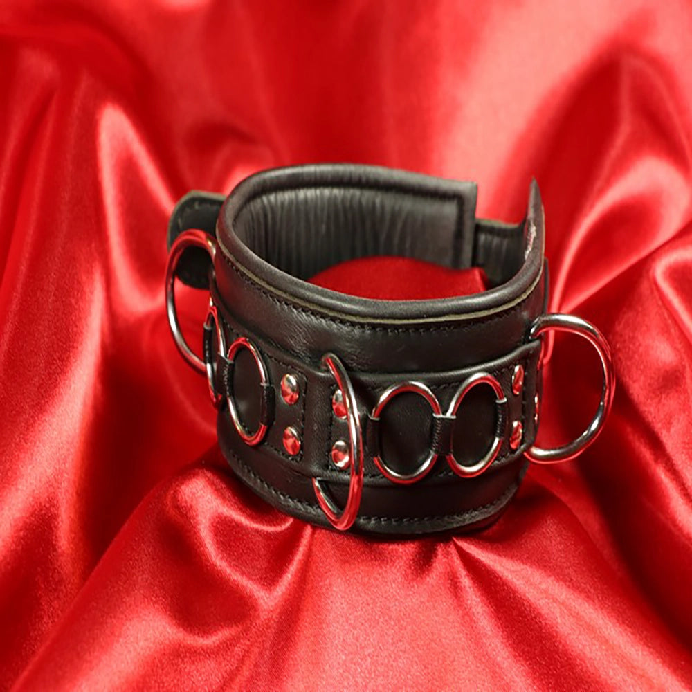 BDSM-halsband dekor ringar – svart vadderat läderhalsband – närbild dekorativa metallringar och nitar på framsidan från Chambers of Love