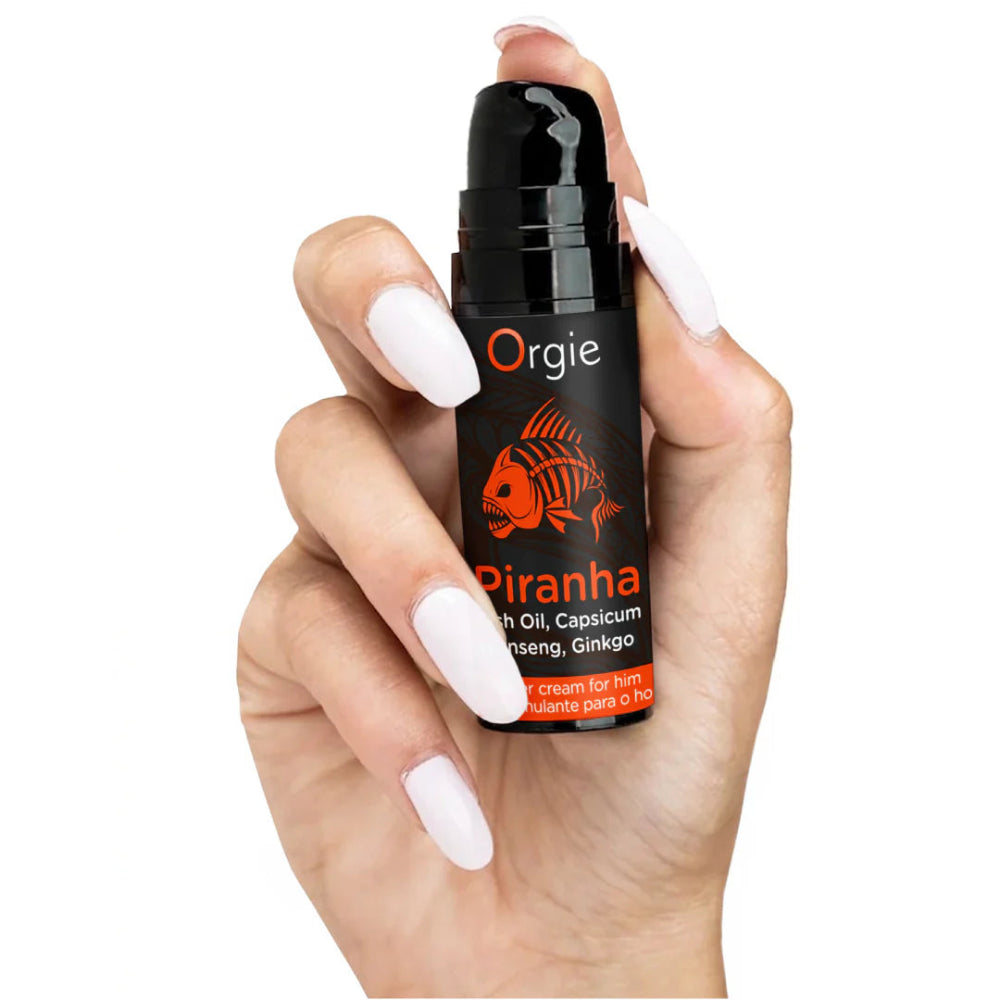 Hand håller Orgie Piranha Power Cream - stimulerande kräm för honom med fiskolja, capsicum, ginseng och ginkgo Hos Chambers of Love 