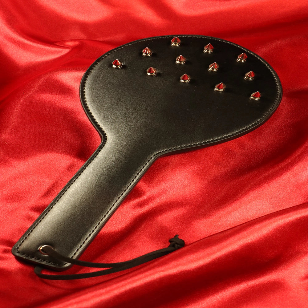 Spik paddel framsida från Chambers of Love – svart vegan läder med metall nitar för BDSM sessioner